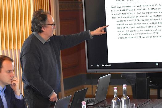 Andrej Kugler popisuje úspěchy projektu FAIR-CZ. Vlevo ředitel ÚJF Ondřej Svoboda.
