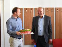 Nastupující ředitel ÚJF AV ČR Ondřej Svoboda (zleva) předává dort svému předchůdci Petru Lukášovi