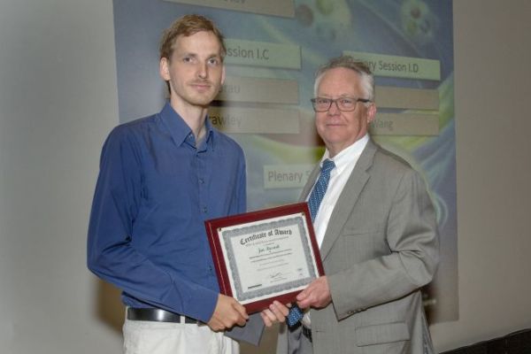 BNL director Doon Gibbs is awarding Jan Rusnak with the best thesis certificate. Source: Brookhaven National Laboratory