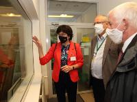 President of the CAS Eva Zažímalová in front of clean room of AMS laboratory, accompanied by Petr Lukáš and Jan Kučera